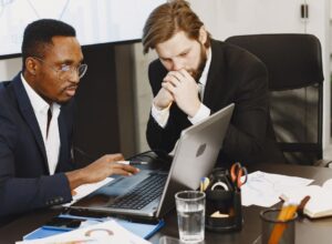 Δύο στελέχη εξετάζουν παραγγελίες και αναφορές σε laptop
